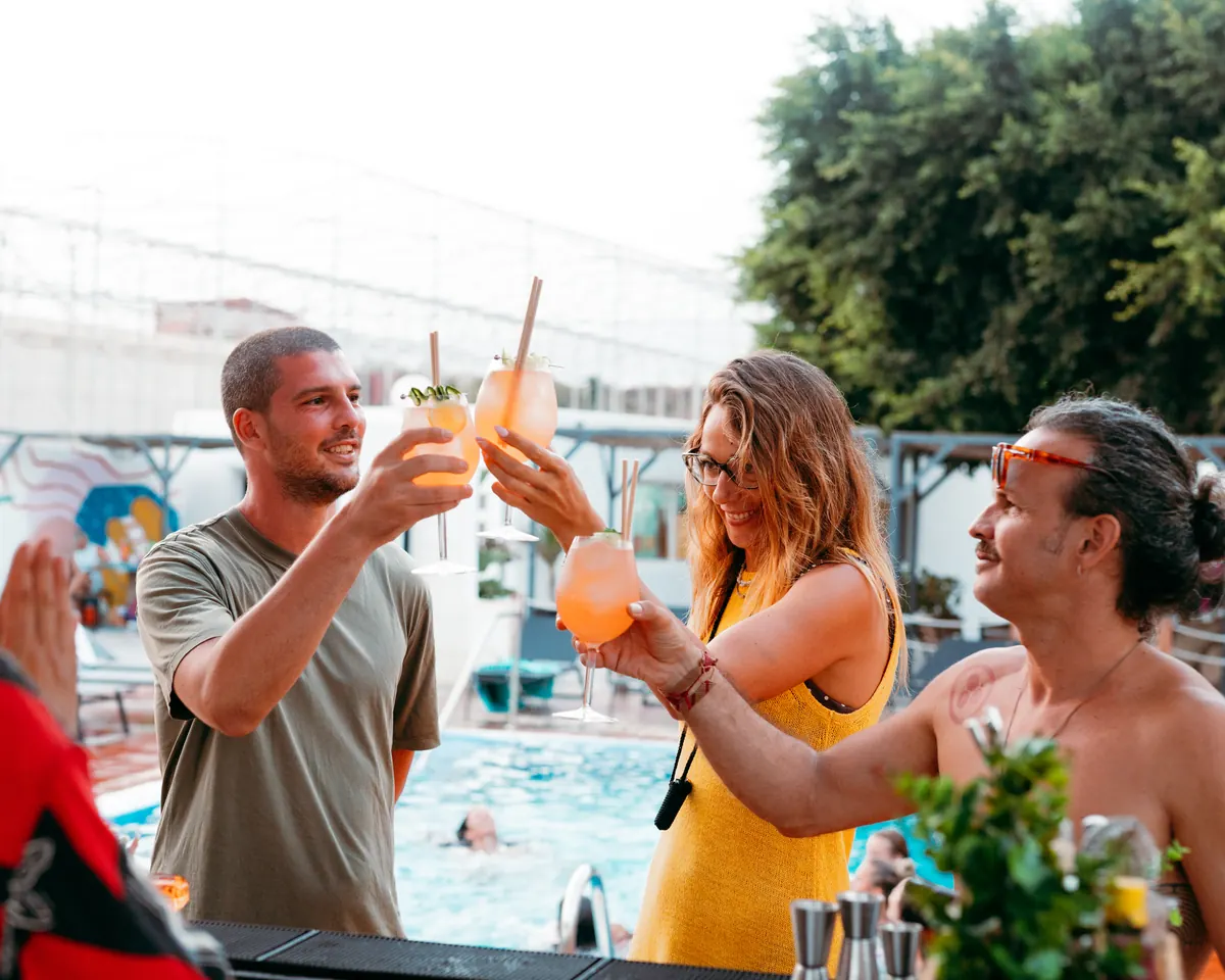 Guests raising their cocktails by the pool