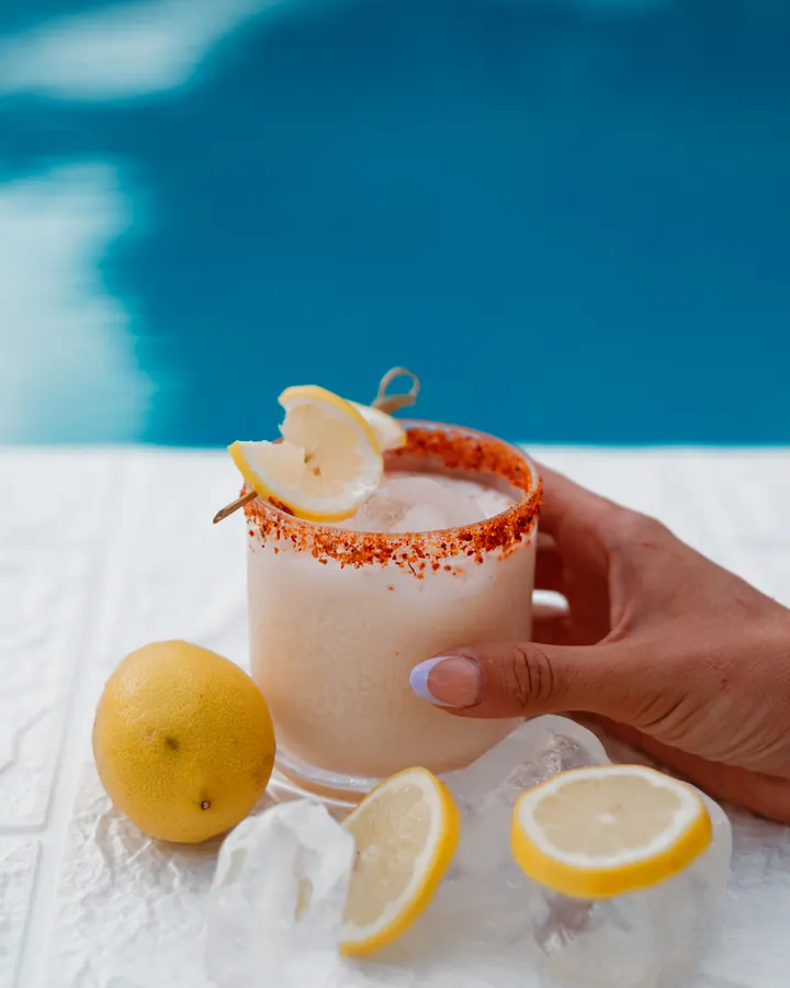 A cocktail with a spiced rim and fresh lemon
